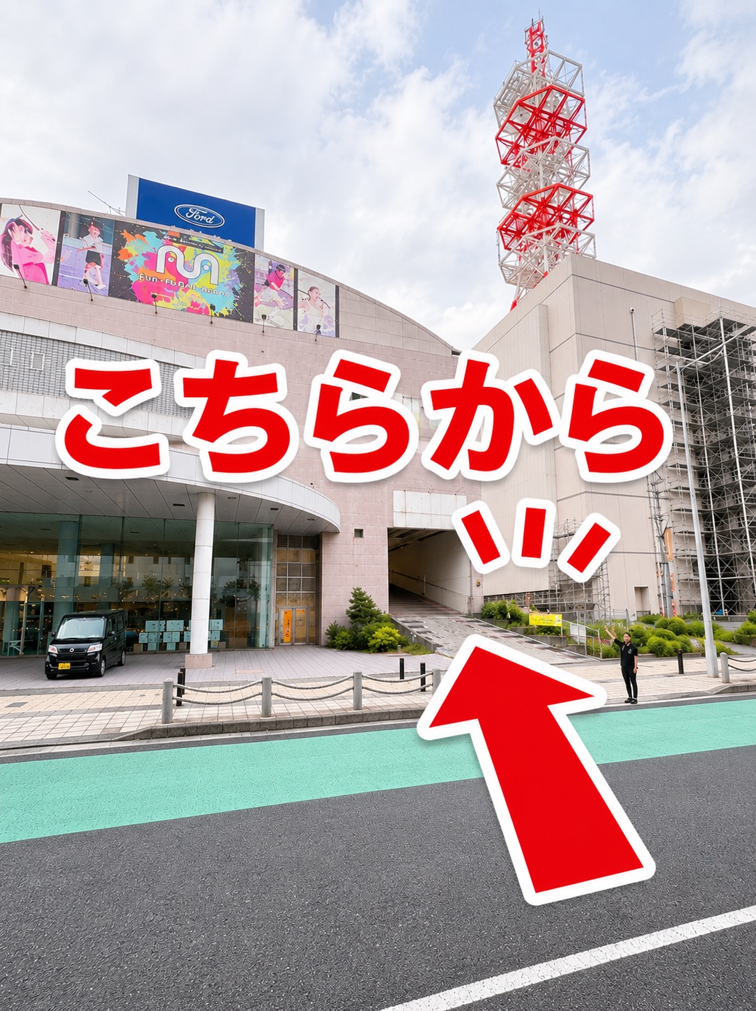 道路側から見た駐車場入口。「こちらから」の案内に従って建物下の通路へ進みます。